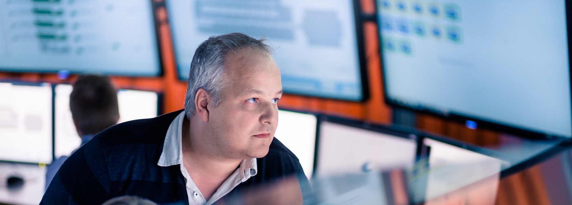 Image of a man looking at different screens
