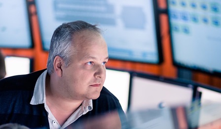 Image of a man looking at different screens