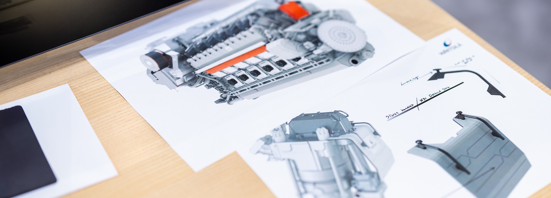 paper sheets with 3D illustration of a Wärtsilä engine on a table