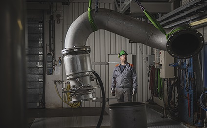 Wärtsilä engineer hoisting a pipe in the test hall