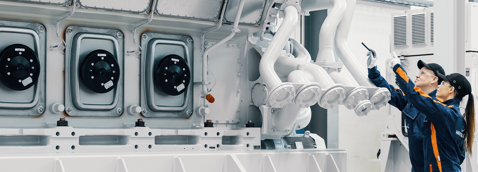 Wärtsilä employees in front of an engine