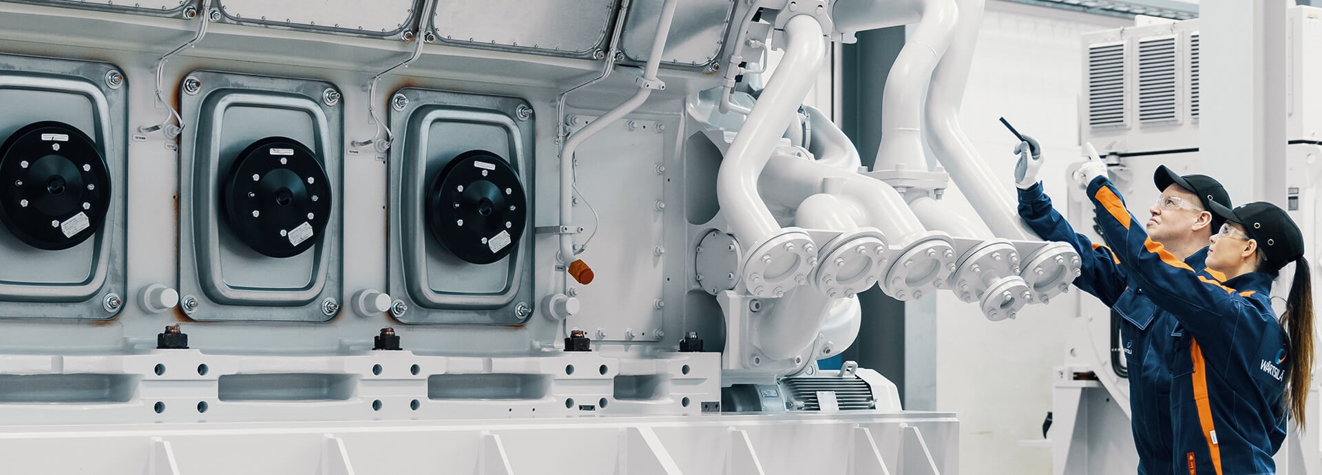 Wärtsilä employees in front of an engine