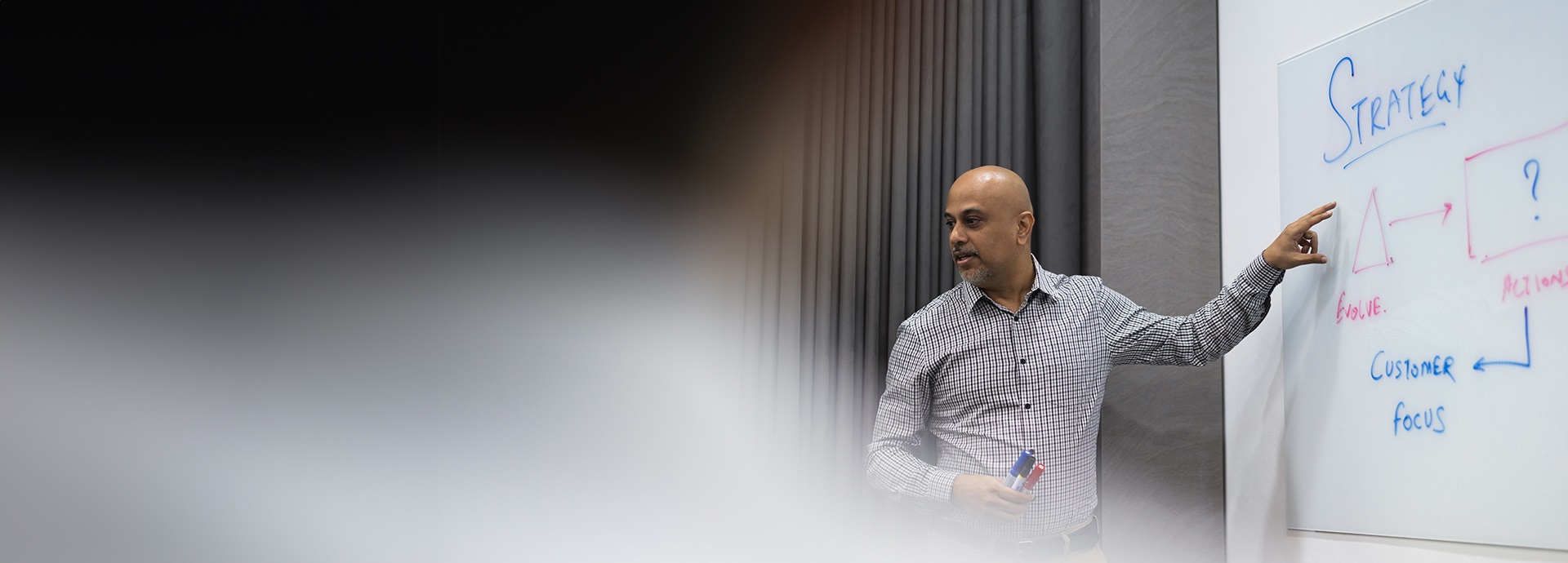 man stands in front of a blackboard