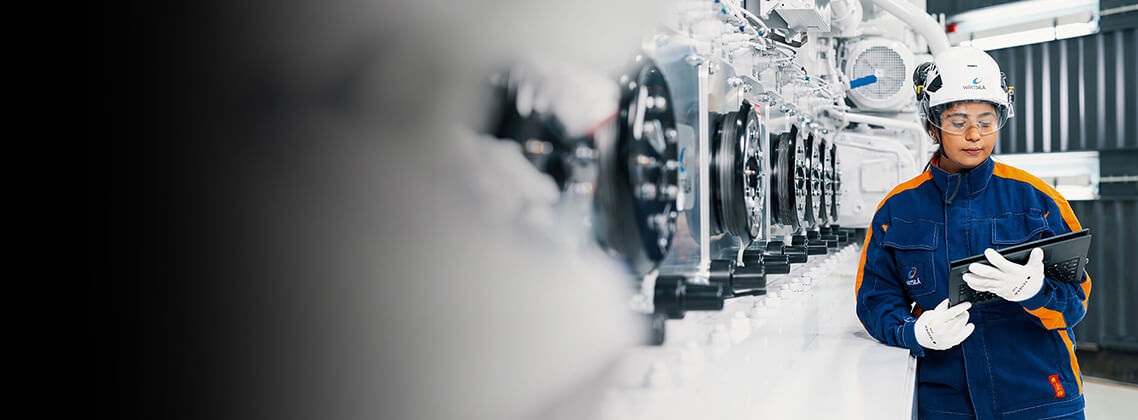 Wärtsilä employee is standing next to the engine