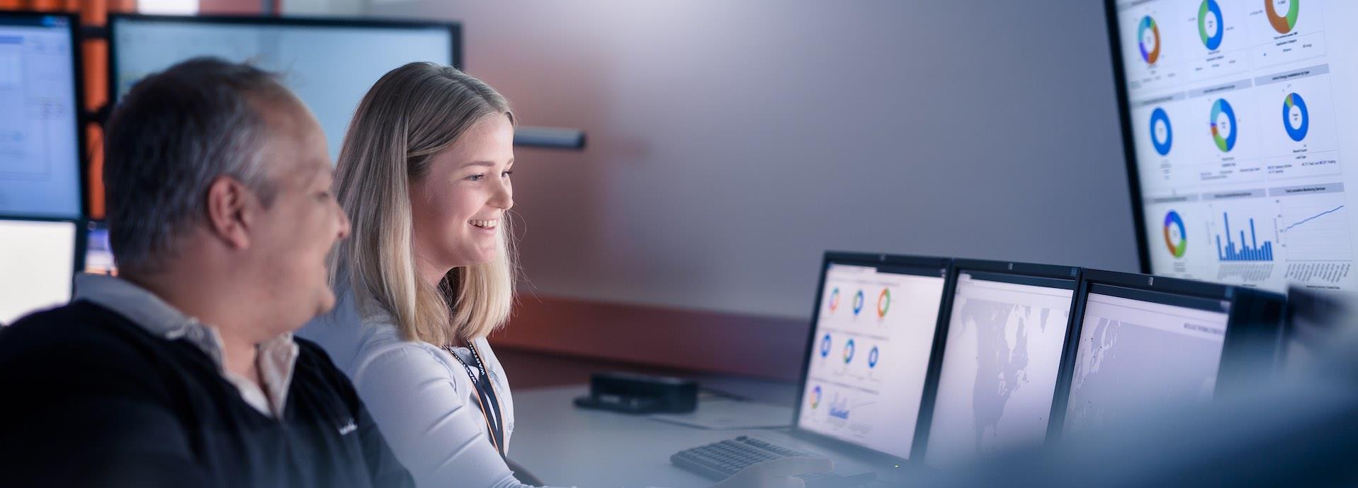 Colleagues in a workplace looking at data on computer screens