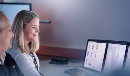Colleagues in a workplace looking at data on computer screens
