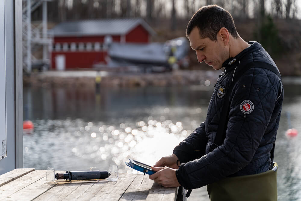 A diver prepares the Onset sensors for data logging and the Valtamer tablet for underwater data reading