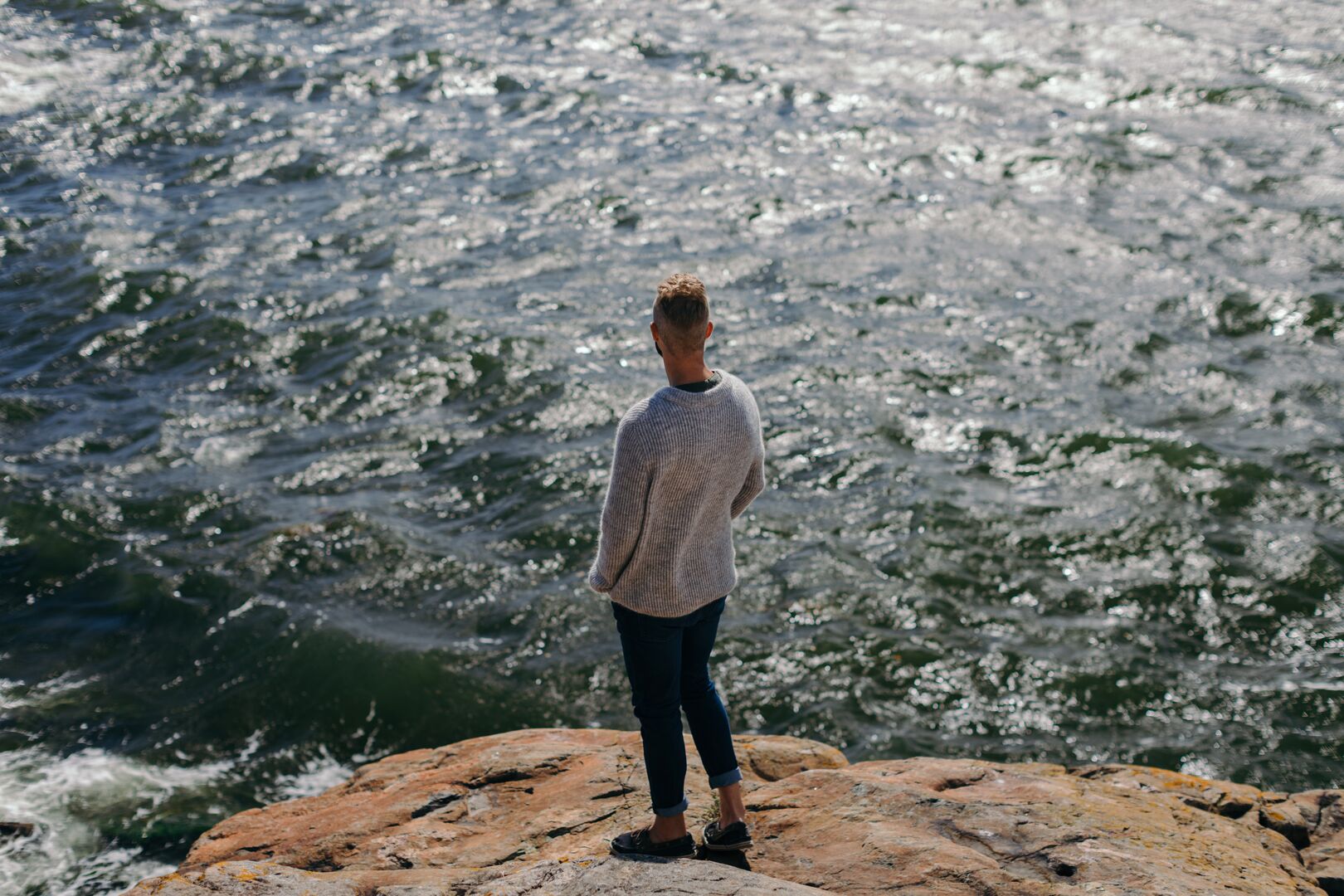 Man standing on a rock watching the sea