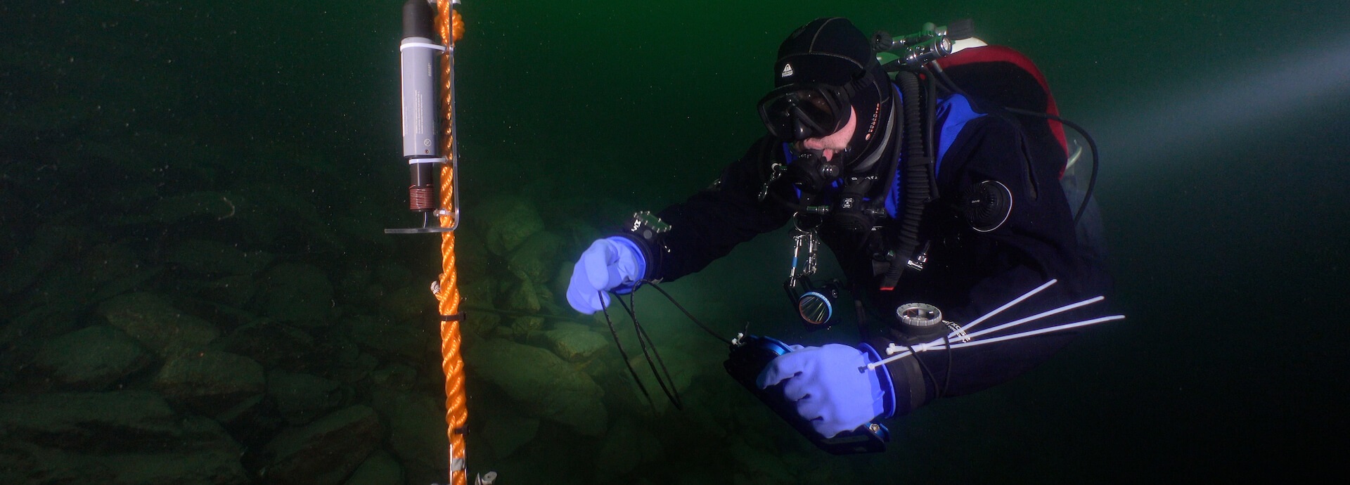 A diver using the Valtamer tablet with its antenna for underwater data reading