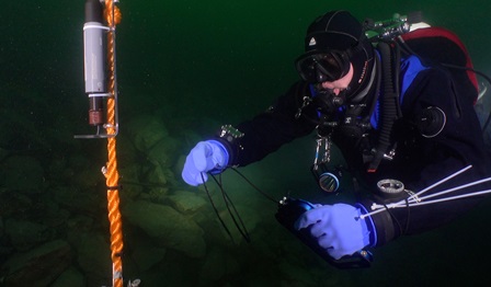 A diver using the Valtamer tablet with its antenna for underwater data reading