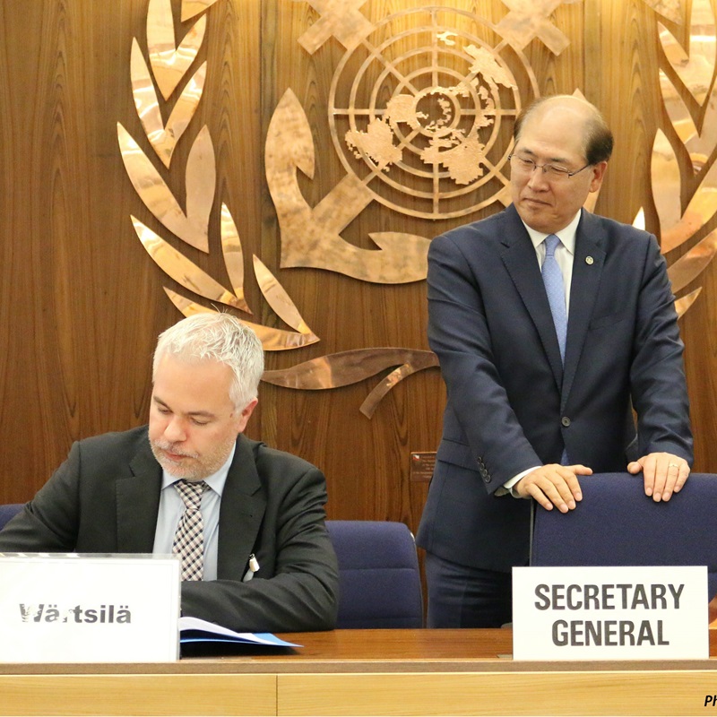 IMO Secretary-General Kitack Lim looking on as Marko Vainikka, Director of Corporate Relations & Sustainability, signs the GIA agreement on behalf of Wärtsilä Corporation.