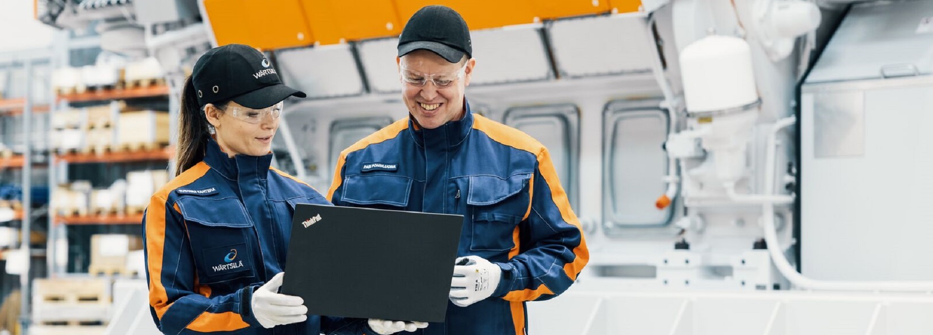 Two field engineers looking at a laptop in an engine hall