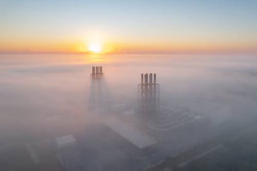 Aerial view of power plant and sunset and fog.