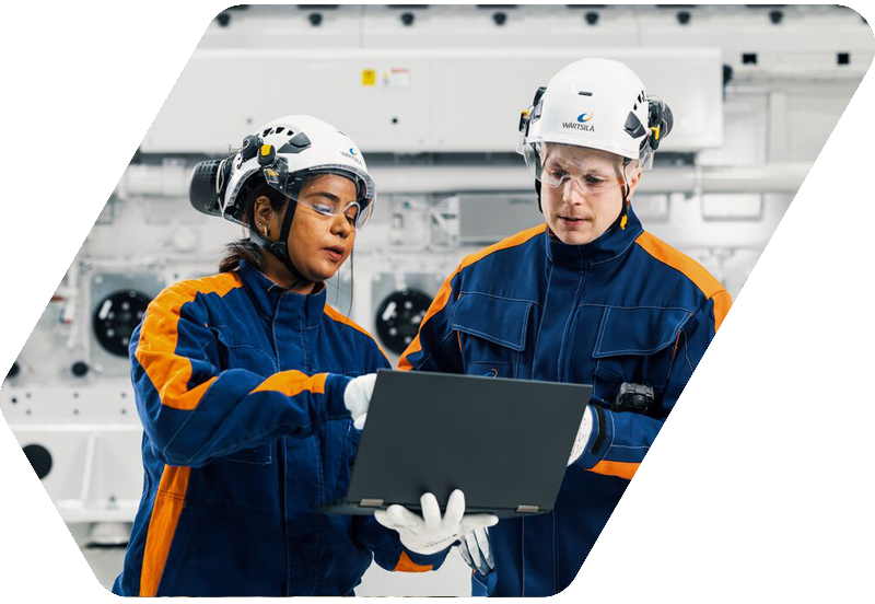 Wärtsilä employees in front of an engine
