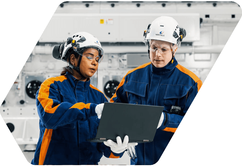 Wärtsilä employees in front of an engine