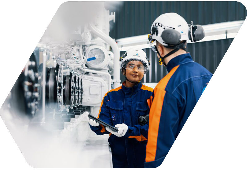 Wärtsilä employees next to an engine