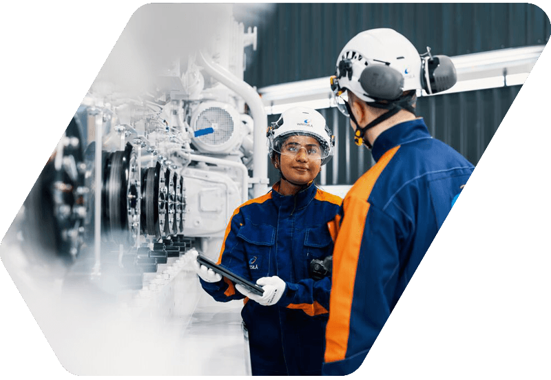 Wärtsilä employees next to an engine