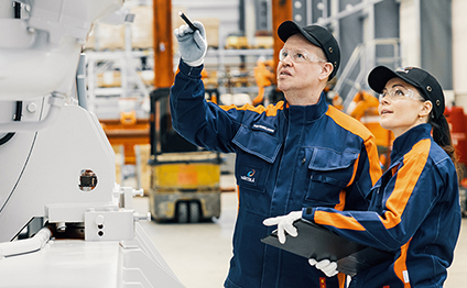 Wärtsilä employees in front of an engine