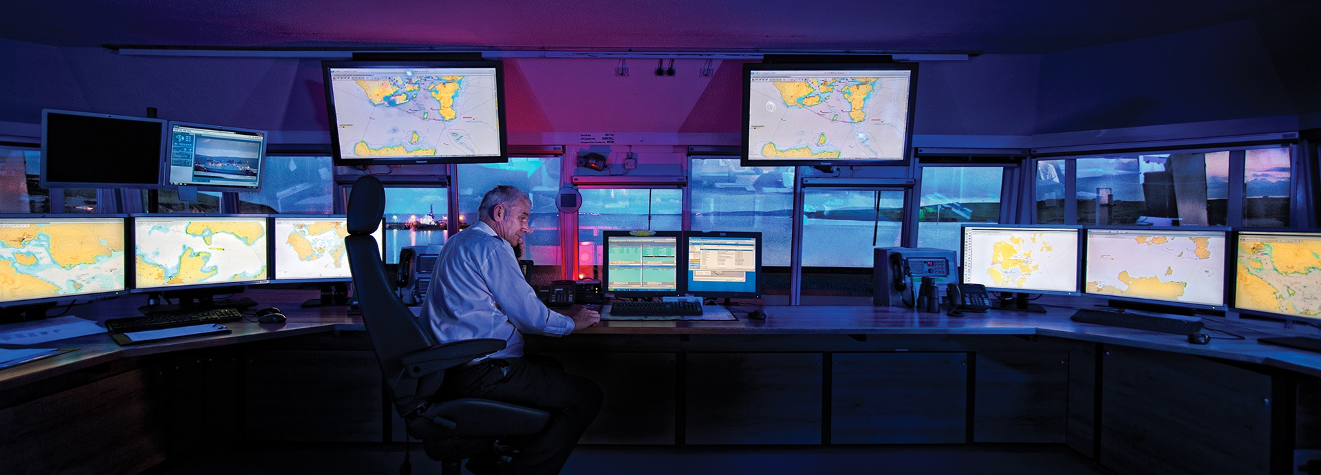 men sitting in front of a Navi-Harbour Vessel Traffic Management System
