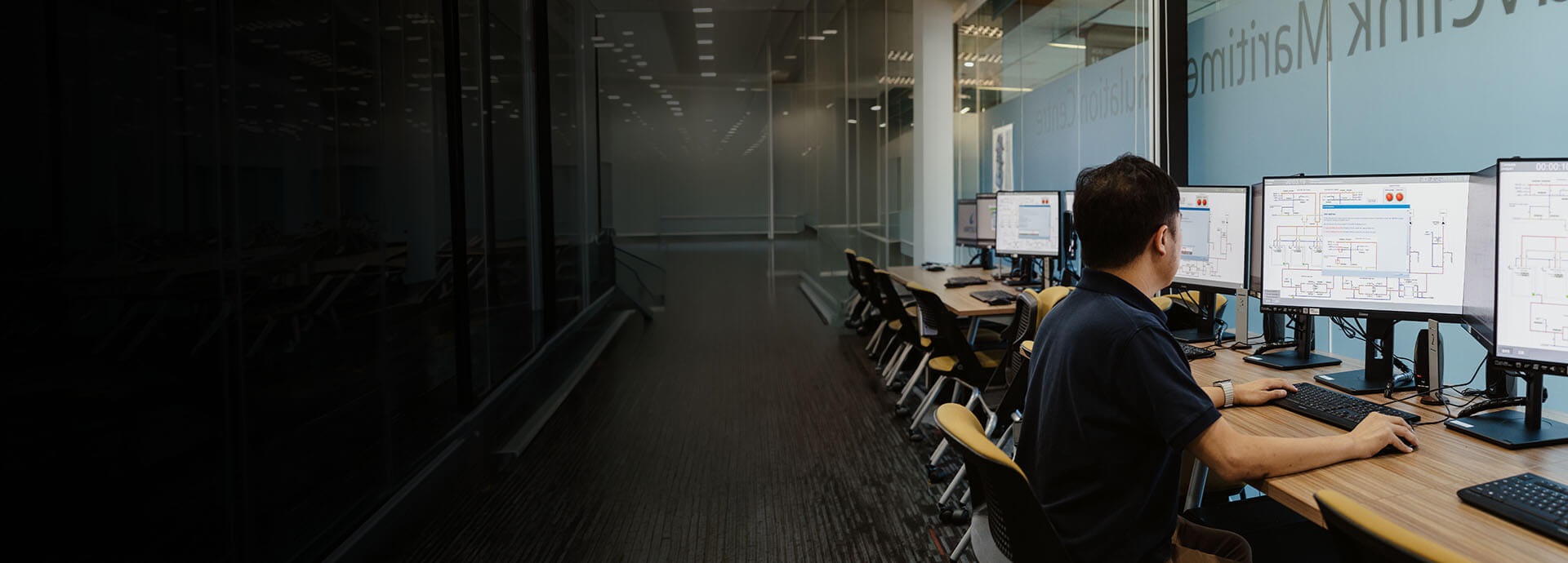 man sits in front of simulator monitors