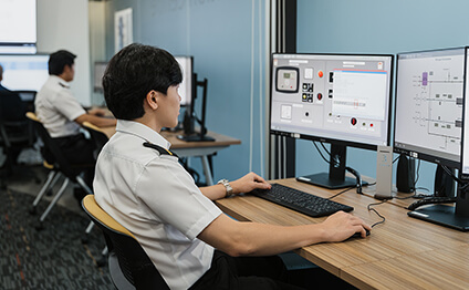 man sits in front of simulator monitors