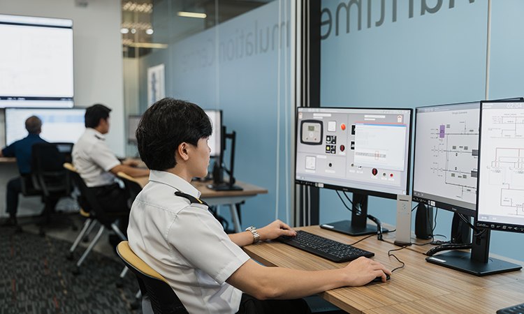woman sits in front of simulator monitors