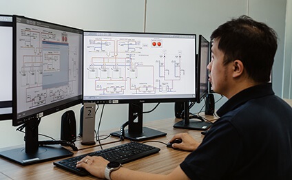 man sits in front of simulator monitors