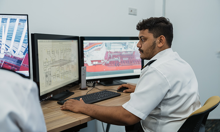 man sits in front of simulator monitors