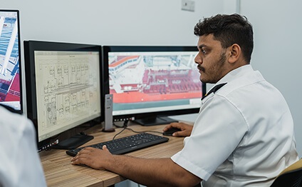 man sits in front of simulator monitors