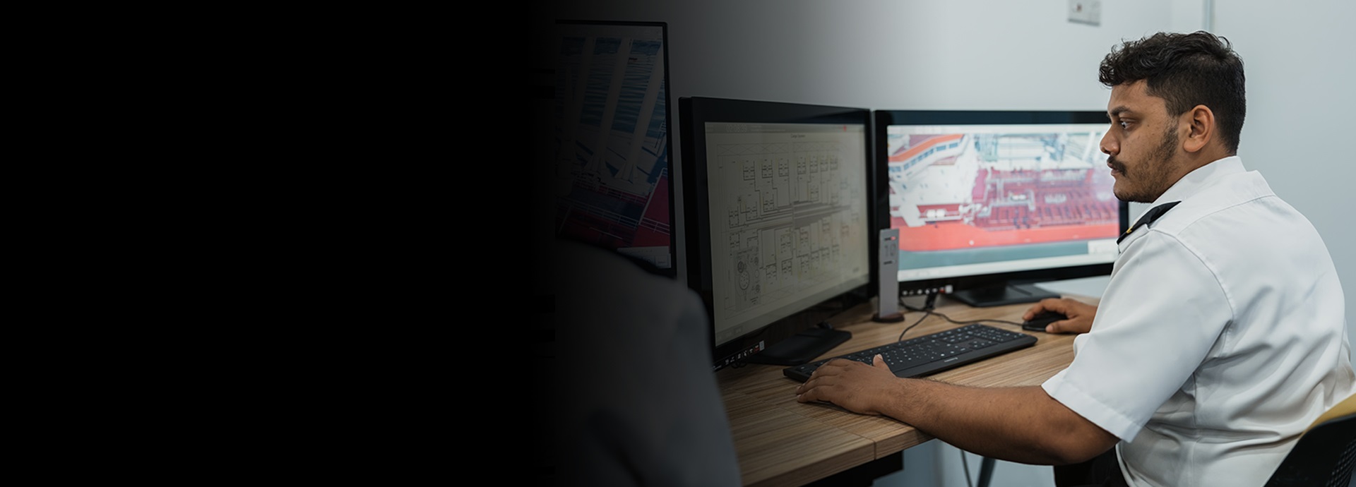 man sits in front of simulator monitors