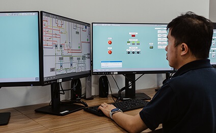 man sits in front of simulator monitors