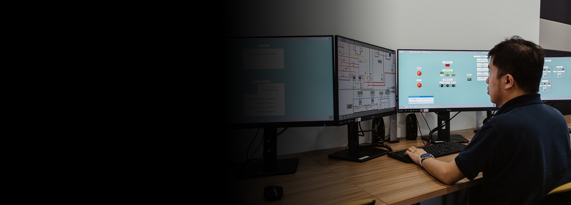 man sits in front of simulator monitors