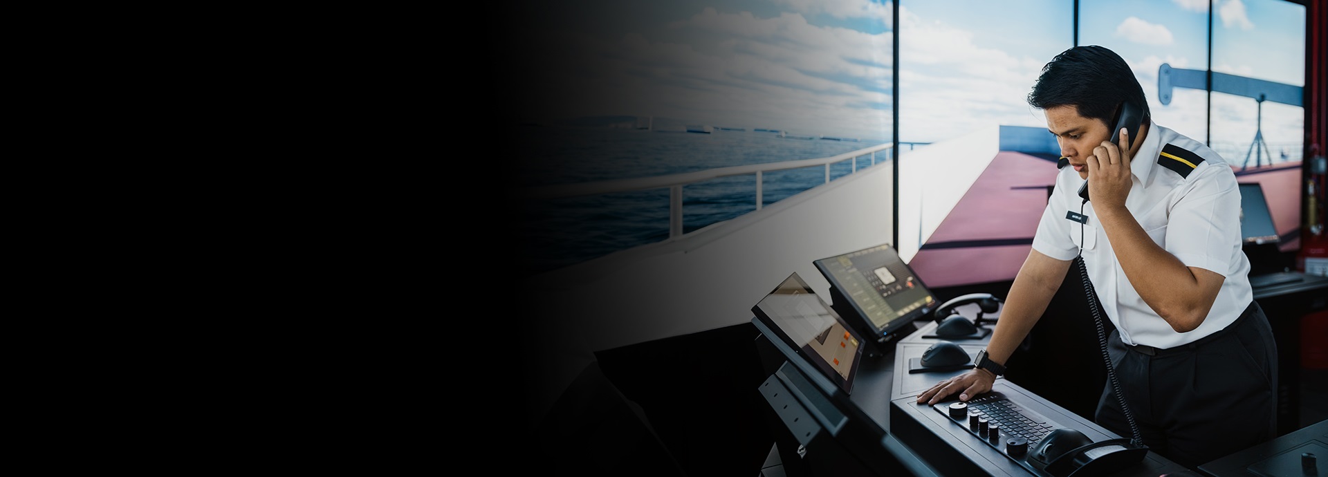 A man in front of a GMDSS simulator