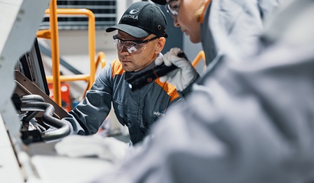 Wärtsilä employees in front of an engine