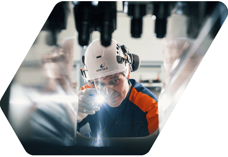 Wärtsilä factory worker in front of an engine